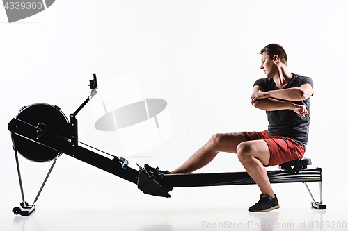 Image of Man Using A Press Machine In A Fitness Club.