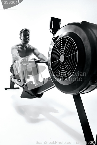 Image of Man Using A Press Machine In A Fitness Club.