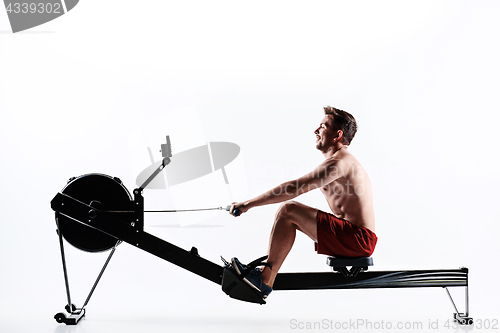 Image of Man Using A Press Machine In A Fitness Club.