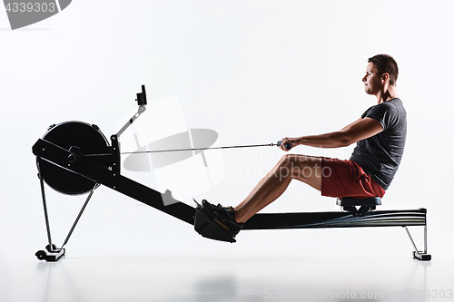Image of Man Using A Press Machine In A Fitness Club.