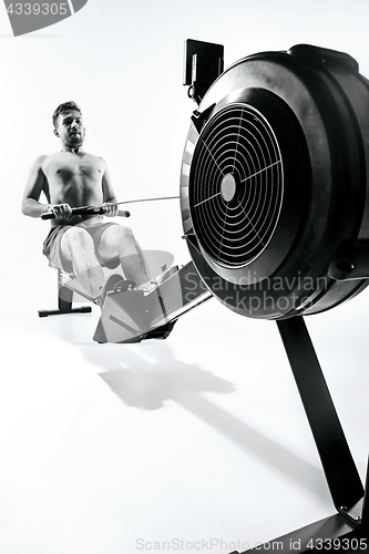 Image of Man Using A Press Machine In A Fitness Club.