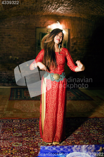 Image of young pretty asian girl in bright colored interior on carpet