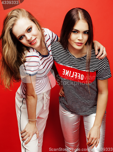 Image of two best friends teenage girls together having fun, posing emotional on red background, besties happy smiling, lifestyle people concept 
