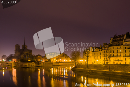 Image of Notre Dame Cathedral with Paris cityscape at dusk