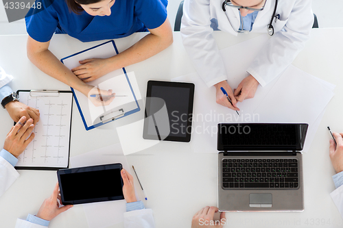 Image of doctors with cardiogram and computers at hospital