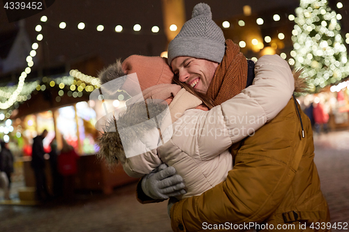 Image of happy couple hugging at christmas tree