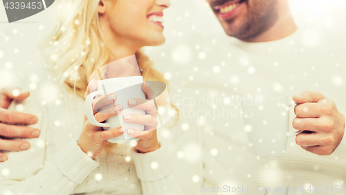 Image of close up of happy couple with tea cups at home