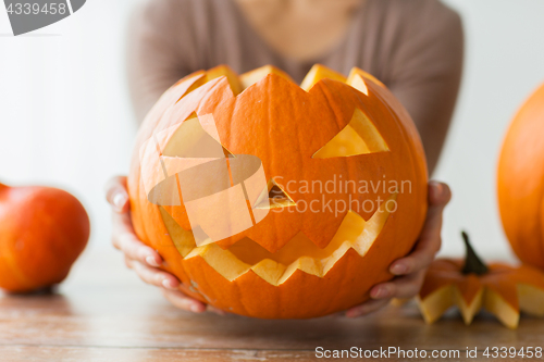 Image of close up of woman with halloween pumpkin at home