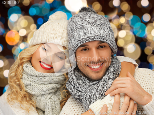 Image of happy couple in hats over lights background