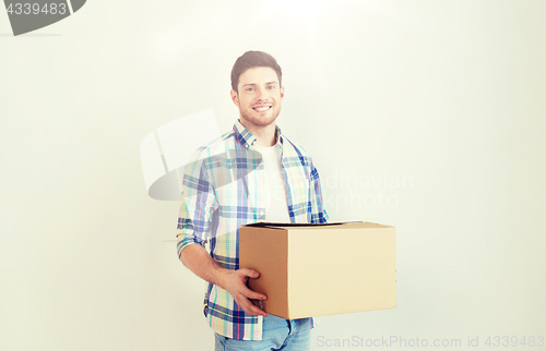 Image of smiling young man with cardboard box at home