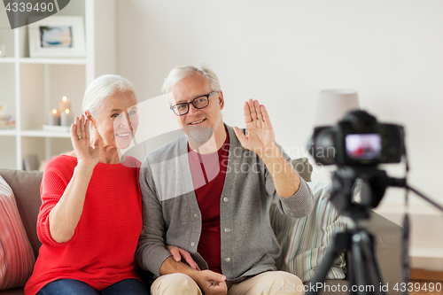 Image of happy senior couple with camera recording video