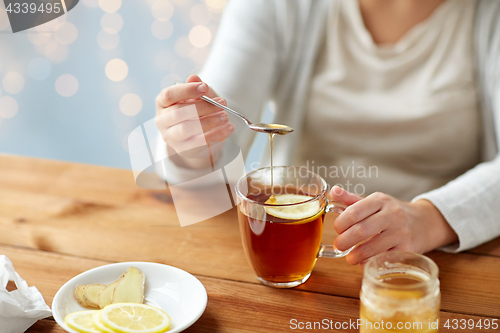 Image of close up of ill woman drinking tea with lemon