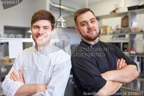 Image of happy smiling chef and cook at restaurant kitchen