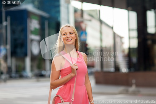 Image of happy smiling young woman on city street