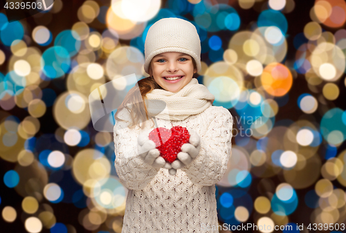 Image of happy girl in winter clothes with red heart