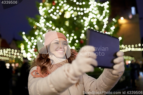 Image of woman with tablet pc at christmas tree outdoors