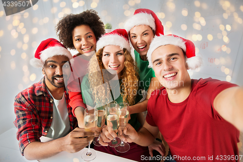 Image of happy friends celebrating christmas at office party