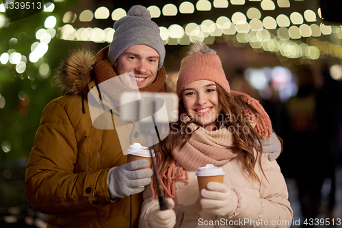 Image of couple with coffee taking selfie at christmas