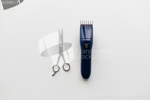 Image of hair trimmer and scissors on white background