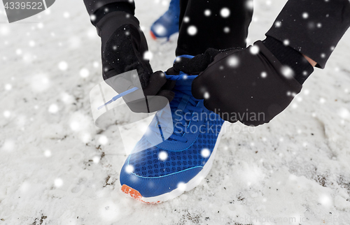 Image of close up of man tying shoe lace in winter outdoors