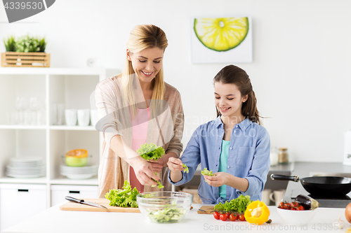 Image of happy family cooking salad at home kitchen