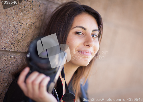 Image of Young Adult Ethnic Female Photographer Against Wall Holding Came