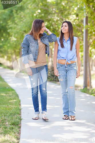 Image of Two Beautiful Ethnic Twin Sisters Walking Outdoors.