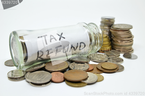 Image of Tax refund lable in a glass jar with coins spilling out