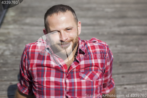 Image of bearded handsome man relaxing outdoors in the sun