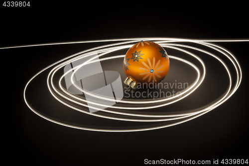 Image of an orange christmas ball with light streaks