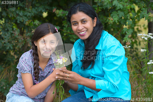 Image of Daughter gives flowers to her mother