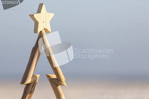 Image of Wooden Christmas tree against beach background