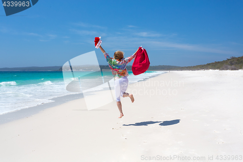 Image of Celebrate Christmas in Australia - female jumping for joy on bea