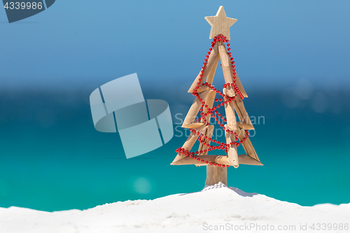 Image of Driftwood Christmas tree decorated with string of red baubles at