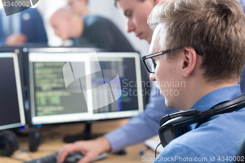 Image of Startup business problem solving. Software developers working on desktop computer.