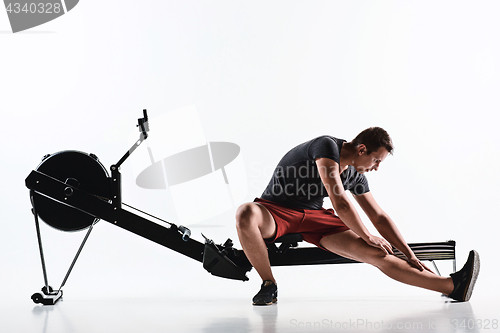 Image of Man Using A Press Machine In A Fitness Club.