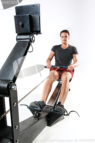 Image of Man Using A Press Machine In A Fitness Club.