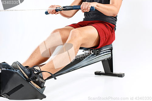 Image of Man Using A Press Machine In A Fitness Club.