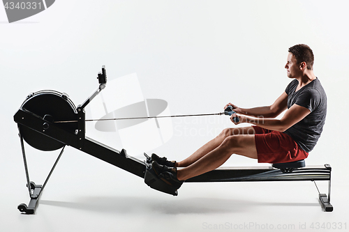Image of Man Using A Press Machine In A Fitness Club.