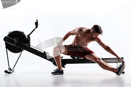 Image of Man Using A Press Machine In A Fitness Club.