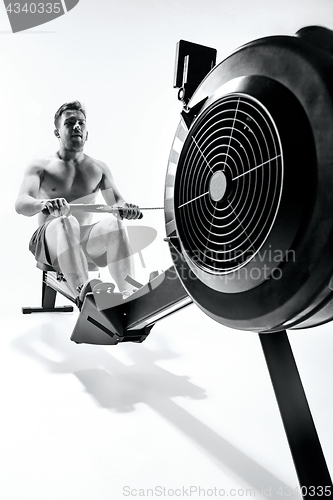 Image of Man Using A Press Machine In A Fitness Club.