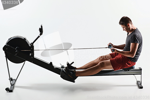 Image of Man Using A Press Machine In A Fitness Club.