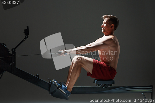 Image of Man Using A Press Machine In A Fitness Club.