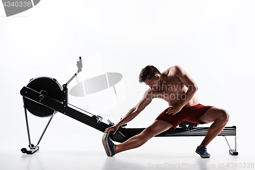 Image of Man Using A Press Machine In A Fitness Club.