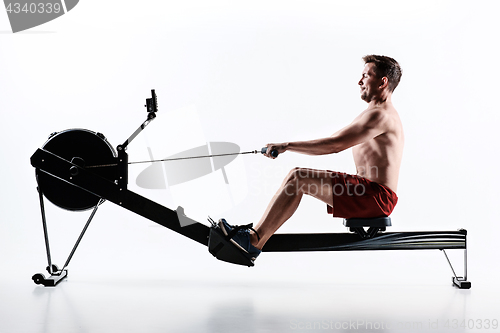 Image of Man Using A Press Machine In A Fitness Club.