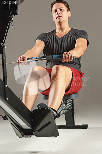 Image of Man Using A Press Machine In A Fitness Club.