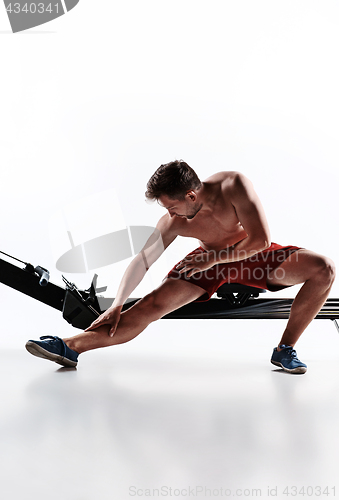 Image of Man Using A Press Machine In A Fitness Club.
