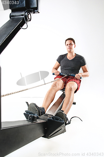 Image of Man Using A Press Machine In A Fitness Club.