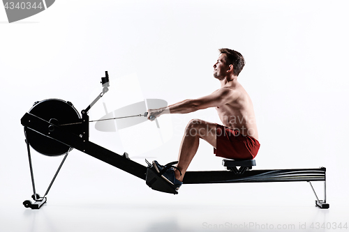 Image of Man Using A Press Machine In A Fitness Club.