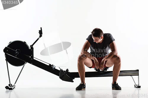 Image of Man Using A Press Machine In A Fitness Club.